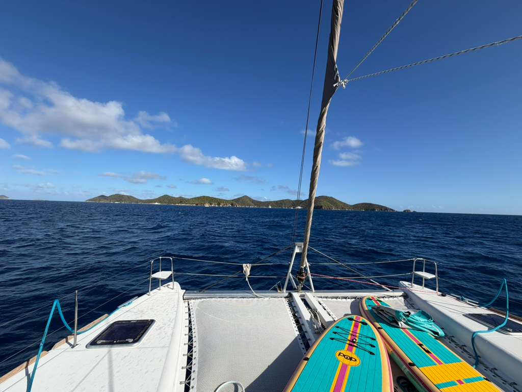 View from Great Adventure’s bow with paddleboards, blue water and islands ahead